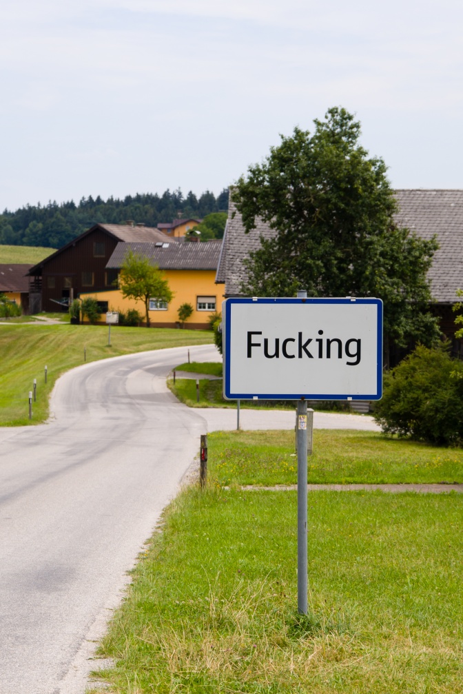 Ein Schild mit der Aufschrift Fucking am Ortseingang eines kleinen Dorfes