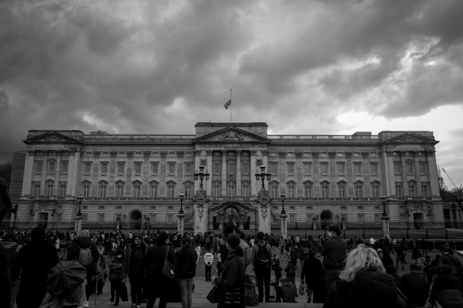 Ein schwarz-weiß-Foto von trauernde Menschen am Buckingham Palast mit einer auf Halbmast wehenden Flagge.