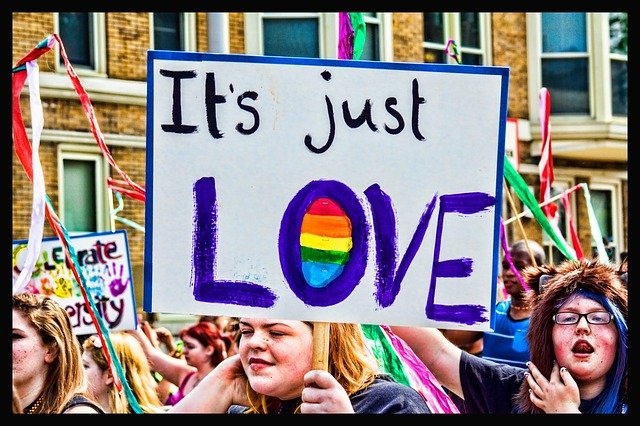 Frauen bei einem CSD. Eine von ihnen hält ein Schild mit der Aufschrift: It's just love.
