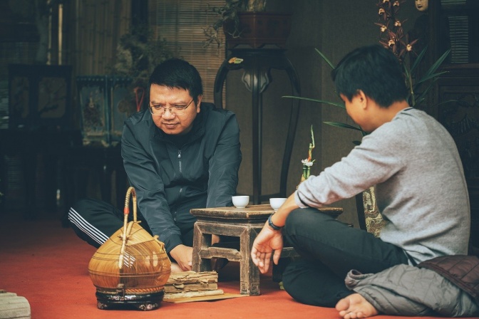 2 asiatische Männer sitzen zusammen und trinken Tee