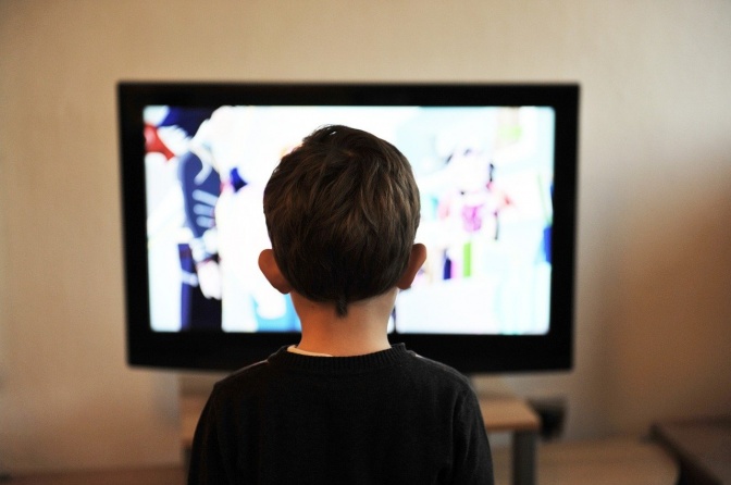 Ein Junge sitzt vor einem Fernseher