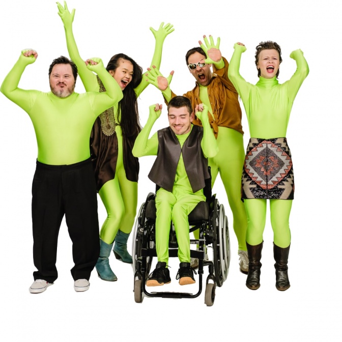 Eine Gruppe von Künstler*innen mit Behinderung in neonfarbener Kleidung