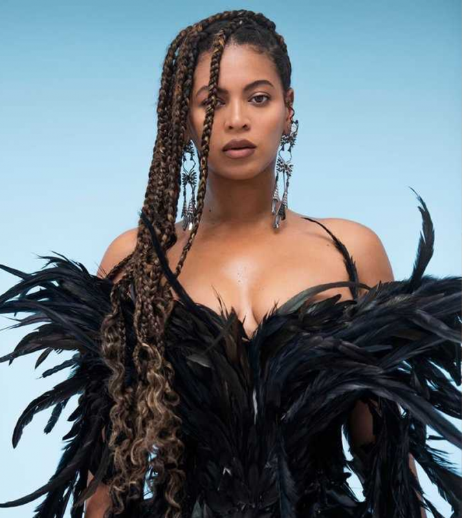 Beyoncé mit langen, geflochtenen Zöpfchen in einem schwarzen Federkostüm