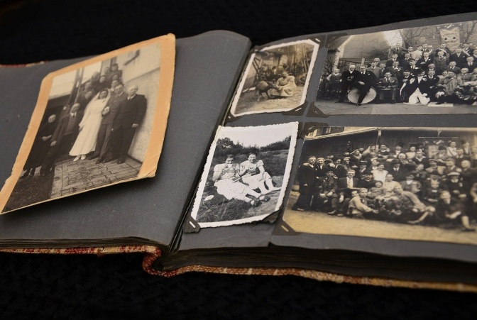 Ein altes Fotoalbum mit mehreren lose eingeklebten schwarz-weiß-Fotos