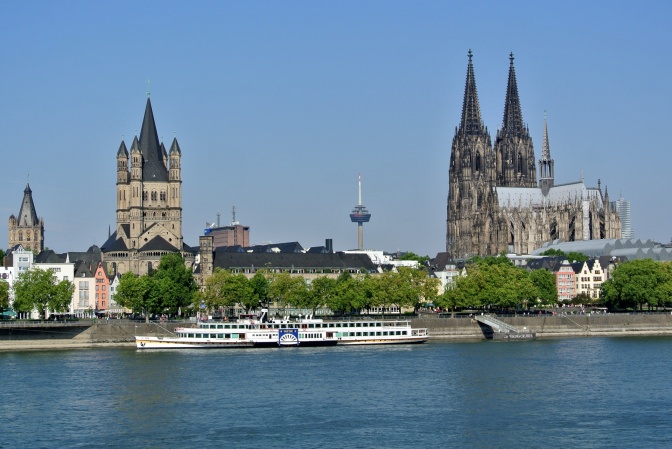 Der Rhein im Vordergrund, im Hintergrund der Dom und andere Gebäude.
