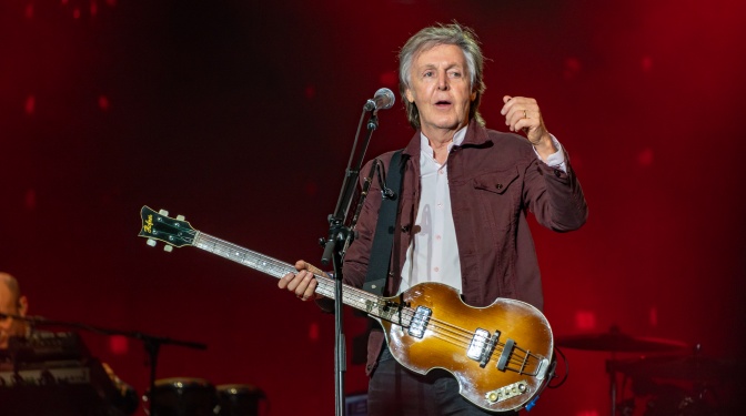 Paul McCartney auf der Bühne mit einem Bass vor einem Mikrophon