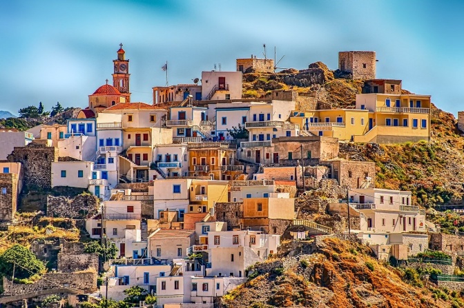 Ein Dorf in Griechenland. Die Häuser haben zum großen Teil flache Dächer und liegen an einem steilen, kargen Berg.