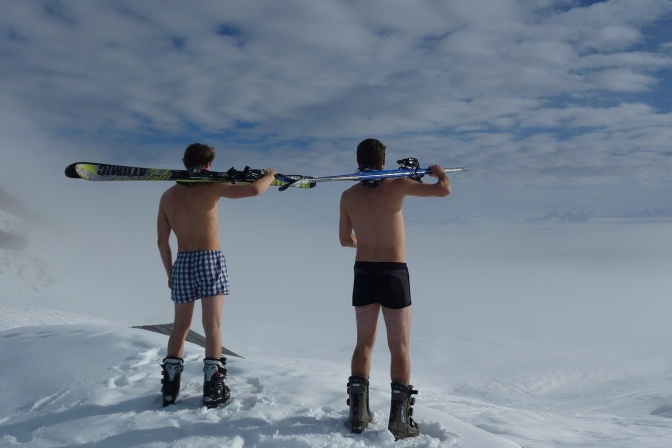 2 Männer in Boxershorts im Schnee, sie haben je ein Snowboard über der Schulter