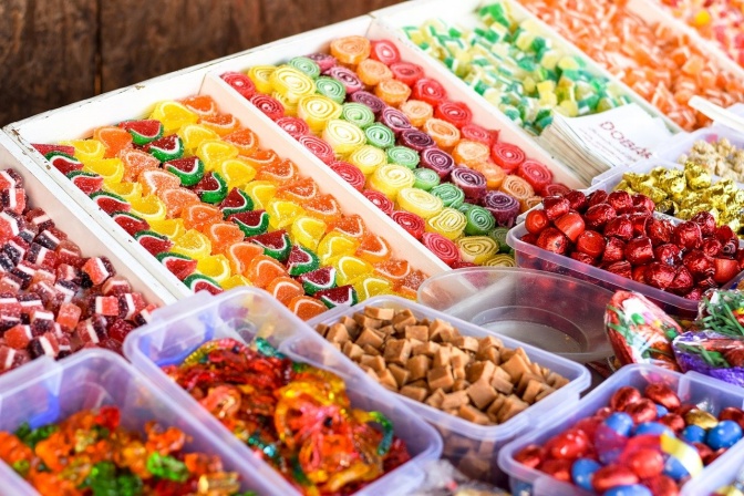 Viele verschiedene bunte Süßigkeiten in Plastikverpackungen