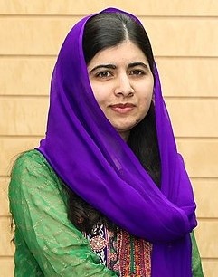 Malala Yousafzai in farbiger Kleidung mit einem Tuch, locker um den Kopf gewickelt. Sie hat schwarze Haare und ist leicht geschminkt.