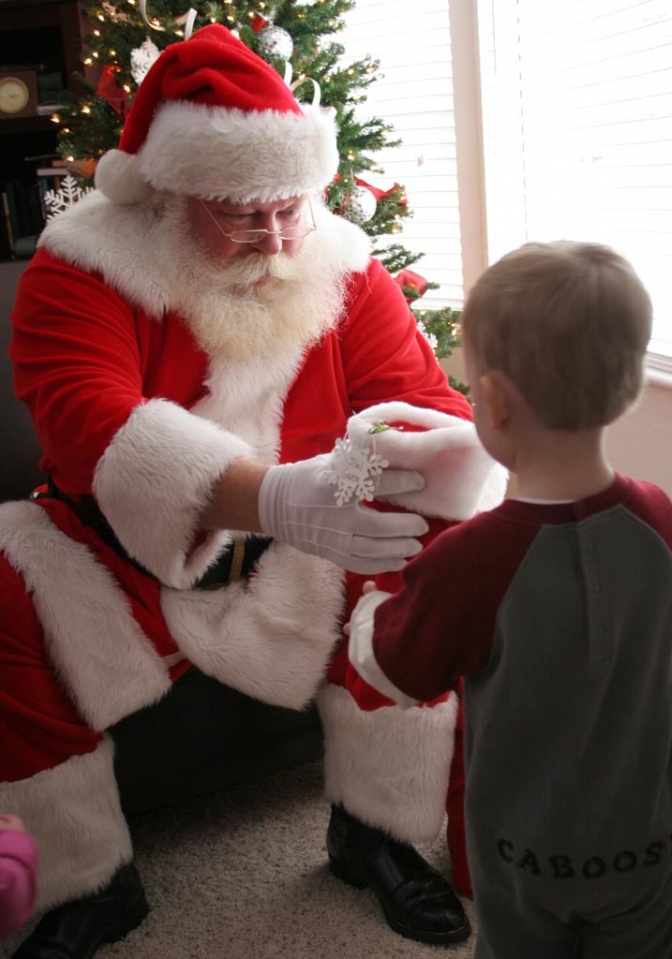 Der Nikolaus und ein kleiner Junge vor einem Weihnachtsbaum