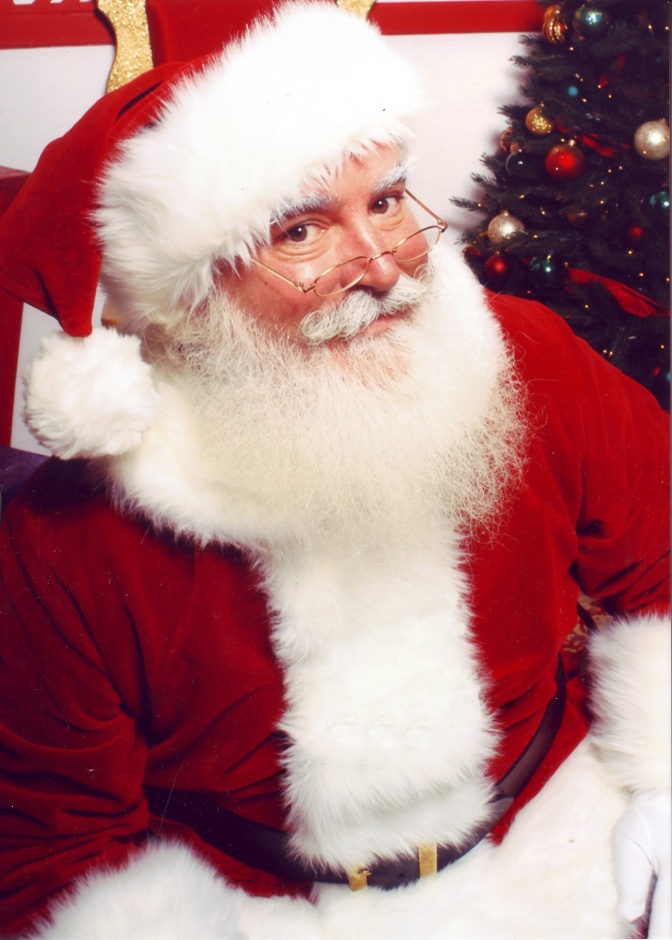 Ein Mann in rot-weißem Weihnachtsmannkostüm mit weißem Vollbart.