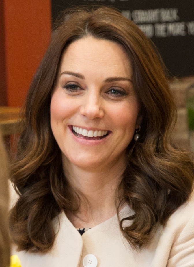 Herzogin Kate lächelnd mit sanft gewellten braunen Haaren