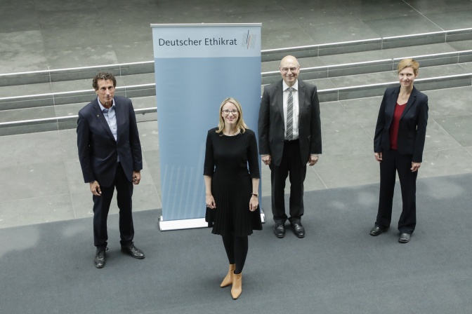 2 Männer und 2 Frauen stehen vor einem Banner mit dem Schriftzug Deutscher Ethikrat