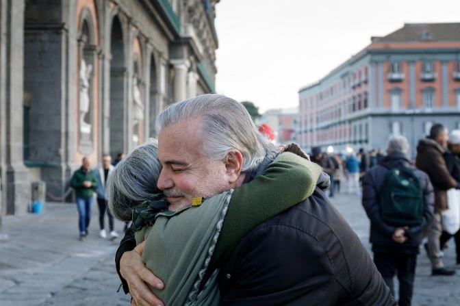 Ein älterer Mann umarmt eine ältere Frau.