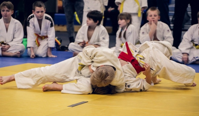 Zwei Judokämpferin ringen auf der Matte miteinander. Beide haben den roten Gürtel.