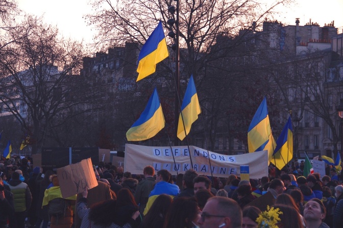 Menschen protestieren gegen den Krieg in der Ukraine. Einige von ihnen tragen ukrainische Flaggen.