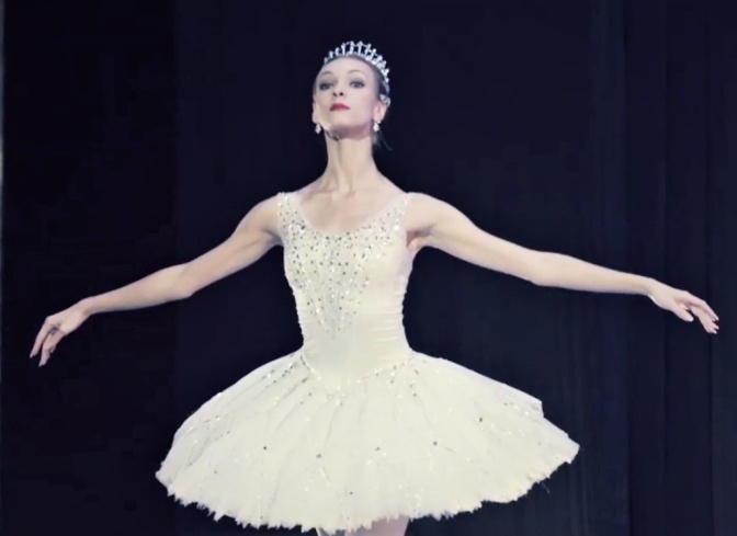 Die Tänzerin Olga Smirnowa in einem klassischen Baleett-Tutu in Tanzposition mit ausgestreckten Armen