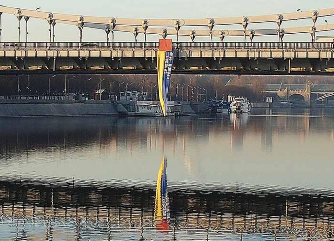 Eine 10 Meter lange ukrainische Flagge hängt an einer Brücke. Darauf steht in kyrillischen Buchstaben: Freiheit, Wahrheit, Frieden.