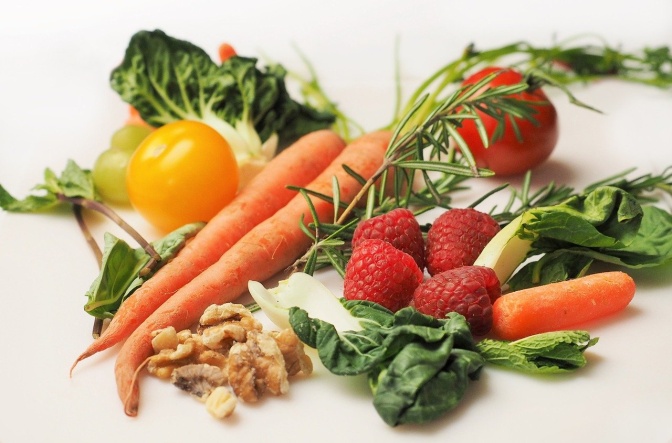 Verschiedene Obst- und Gemüsesorten, unter anderem Möhren, gelbe Paprika, Himbeeren und Tomaten