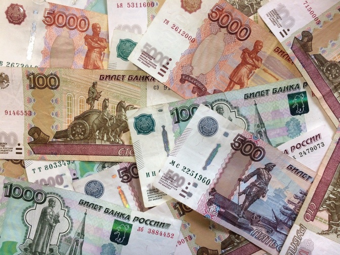 Viele russische Rubel in verschieden großen Scheinen liegen über- und nebeneinander