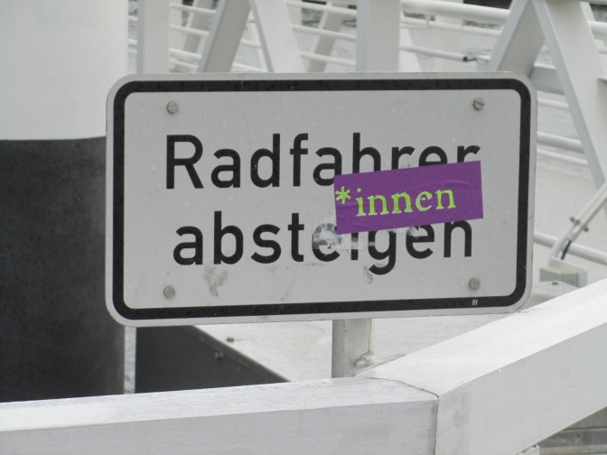 Ein Schild mit dem Text Radfahrer absteigen wurde durch einen Aufkleber mit dem Text *innen ergänzt.