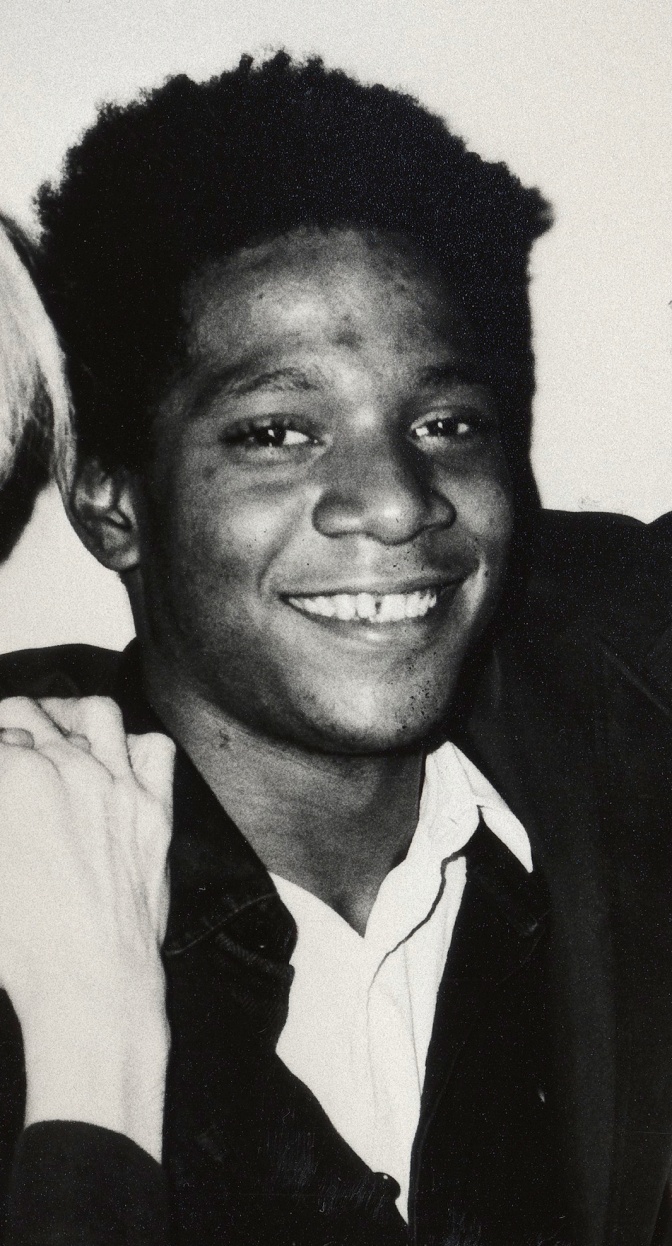 Ein schwarz-weiß-Foto eines lächelnden schwarzen Mannes mit kurzen, krausen Haaren.