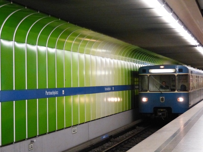 Eine Metro fährt in einen Bahnhof ein. Die Haltestelle heißt Partnachplatz.