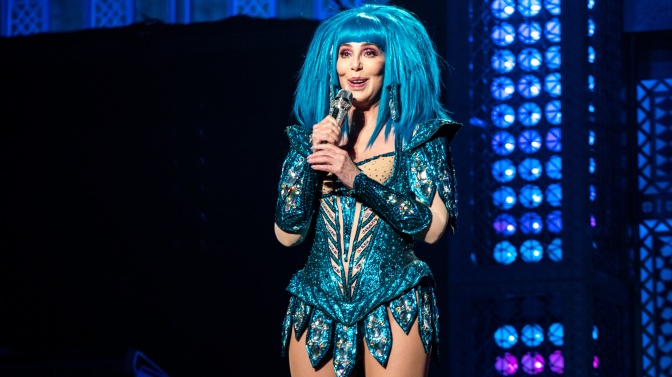 Cher in der Bühne in einem türkisfarbenen kurzen Body und mit türkisfarbener Perücke