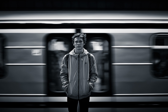 Schwarz-weiß-Foto eines Mannes, der vor einem Zug steht.