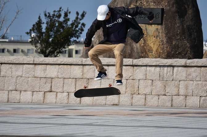 Ein junger Mann macht einen Sprung auf einem Skateboard.