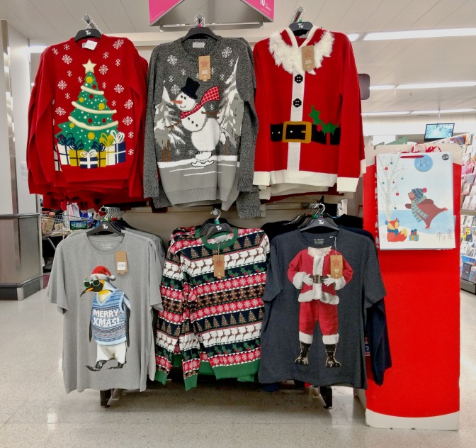 6 verschiedene Weihnachtspullover in verschiedenen Größen in einem Kaufhaus