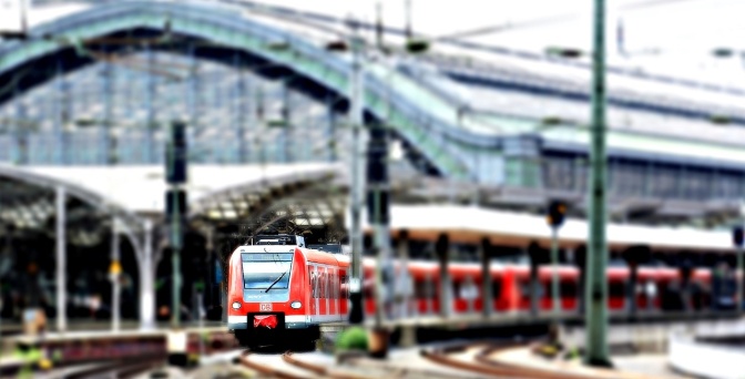 Ein rot-weißer Zug fährt aus dem verglasten Bau des Berliner Hauptbahnhofs heraus.