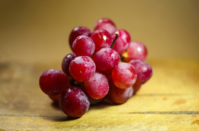 Eine Dolde roter Weintrauben auf einer Hilzfläche
