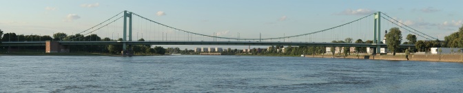 Eine hellgrüne Stahlbrücke über den Rhein in Köln
