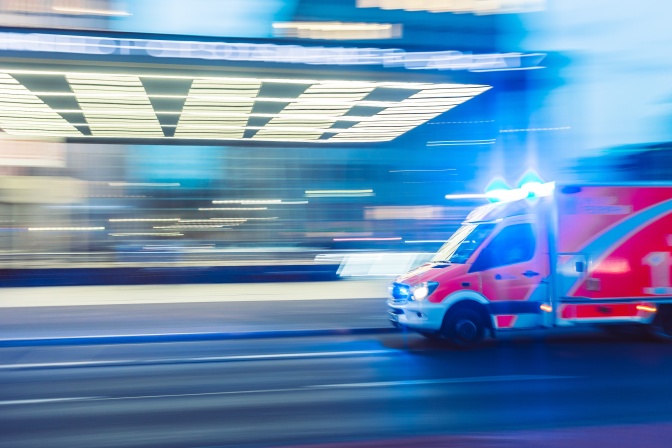 Eine unscharfe Aufnahme eines fahrenden Krankenwagens mit Blaulicht