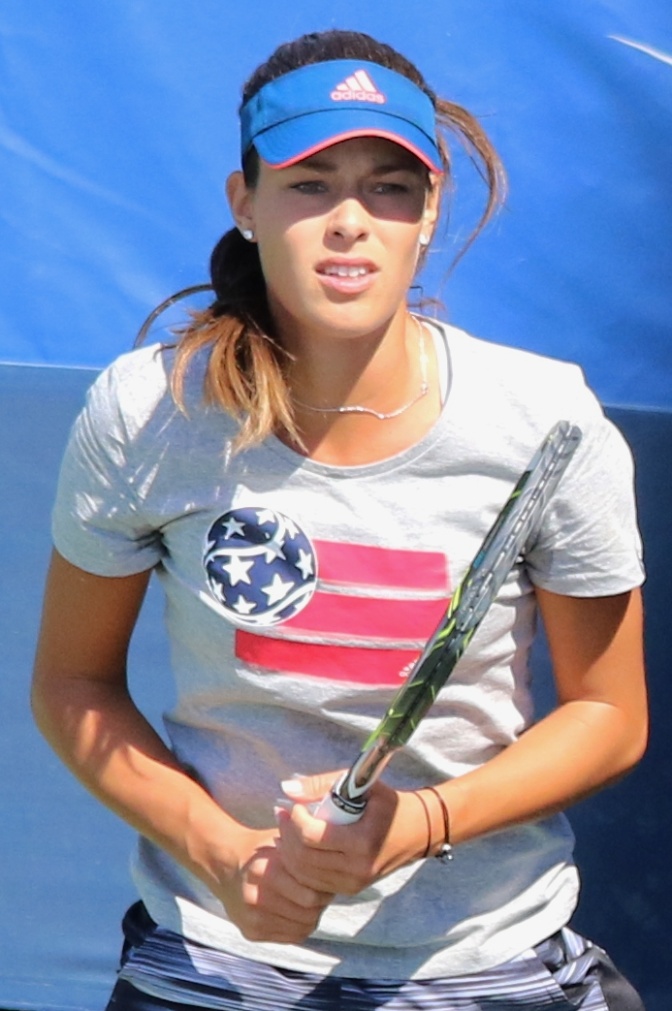 Ana Ivanović mit Schirmmütze und Sportshirt. Sie steht mit einem Schläger in der Hand auf dem Tennisplatz.