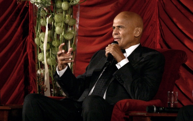Harry Belafonte ist dunkelhäutig. Er hat eine Glatze, sitzt in einem Sessel und spricht