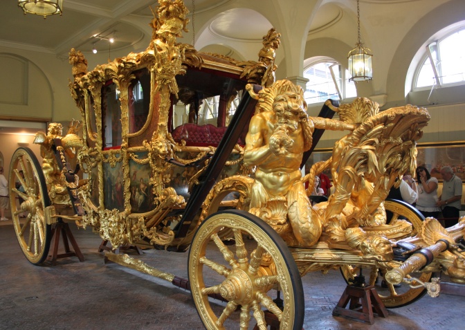 Eine Kutsche ganz aus Gold, verziert mit vielen Figuren aus Gold. Auch die Räder sind golden.