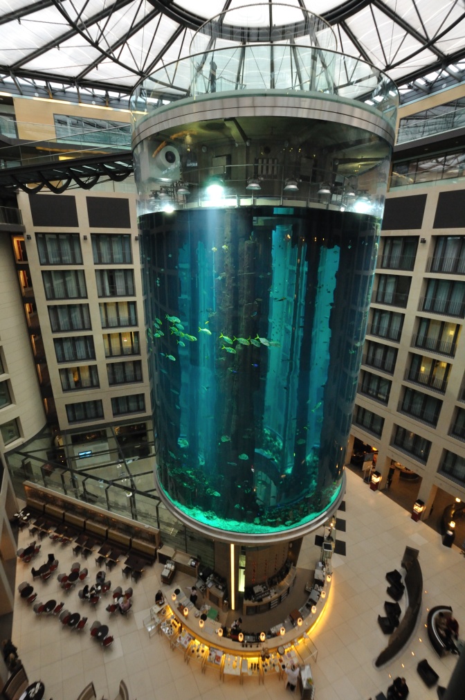 Ein großes zylinderförmiges Aquarium in der Eingangshalle eines Hotels.