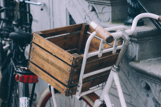 Ein Fahrrad mit einer alten Kiste am vorderen Lenker als Fahrradkorb