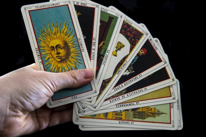 Eine Hand hält Tarotkarten in der Hand.