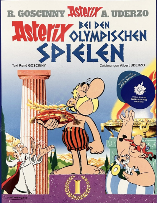Das Cover des Comics Asterix bei den Olympischen Spielen: Asterix steht auf dem ersten Platz des Siegertreppchens und hält einen goldenen Lorbeerkranz auf einem Kissen in der Hand.