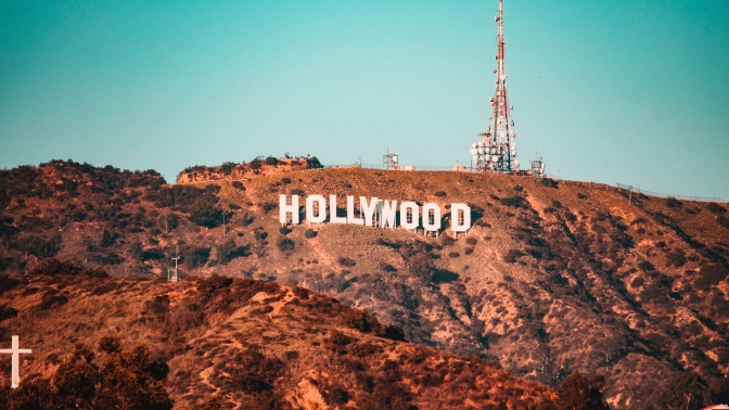 Der Hollywood-Schriftzug in großen, weißen Buchstaben auf einem kargen Hügel mit rötlichem Gestein.