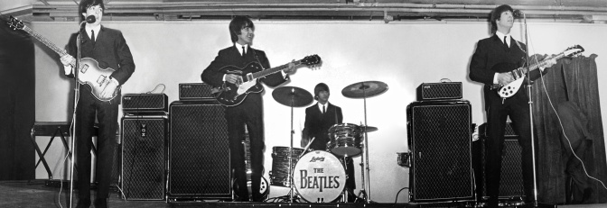 Schwarz-weiß-Fotos der Beatles auf der Bühne in Anzügen und mit den typischen Pilzfrisuren im Jahr 1964.