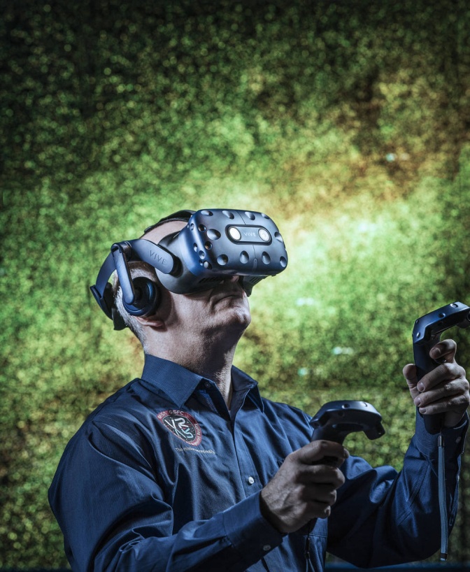 Ein Mann mit VR-Brille bewegt sich durch einen virtuellen Raum.