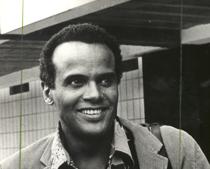 Schwarz-weiß-Foto von Harry Belafonte lächelnd, mit kurzen, krausen Haaren.