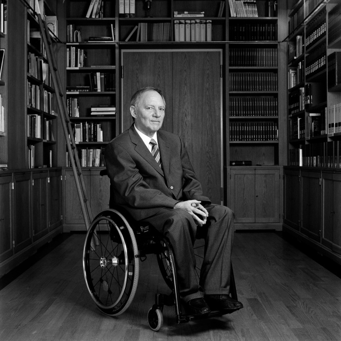 Ein schwarz-weiß-Foto von Wolfgang Schäuble vor einem wandhohen Bücherregal.