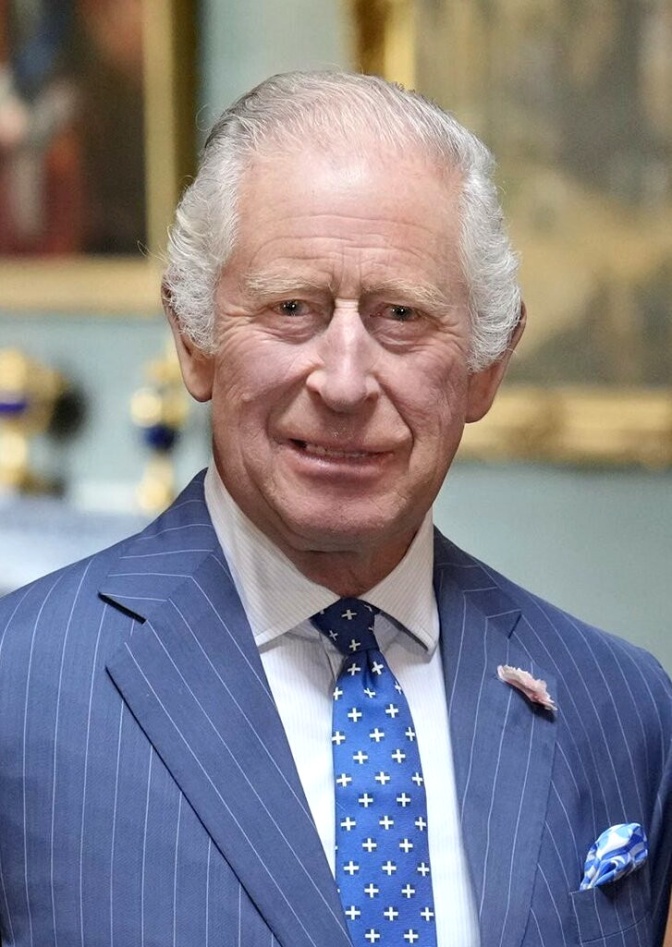 König Charles in einem blauen Anzug mit blauer Krawatte und dünnen weißen Haaren