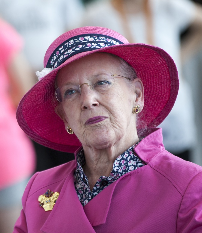 Königin Margrethe in einem pinkfarbenen Kostüm mit großem Hut.